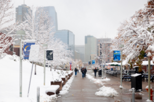 msu denver with snow on the ground and students walking with the denver skyline in background